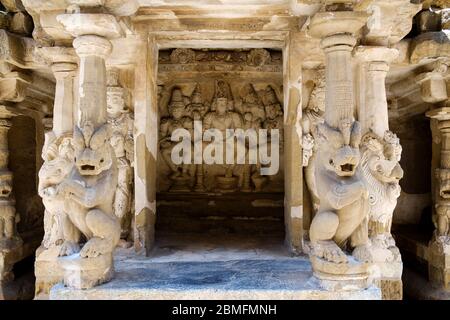 Eine Nische mit Stein-geschnitzten Gottheiten und mythologischen löwenförmigen Säulen am Kailasanathar Tempel, Kanchipuram, Tamil Nadu, Indien. Stockfoto