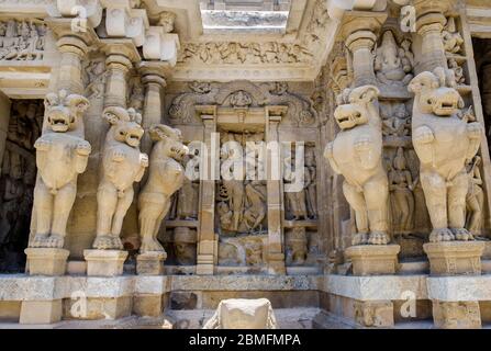 Stein geschnitzte Gottheiten von geschnitzten Säulen in der Form von Löwen, Kailasanathar Tempel, Kanchipuram, Tamil Nadu, Indien eingerahmt. Stockfoto