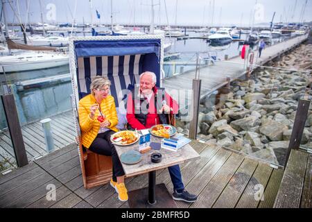 09. Mai 2020, Mecklenburg-Vorpommern, Kühlungsborn: Petra und Ralf-Rainer Schmidt aus Börgerende gehören zu den ersten Gästen auf der Terrasse des wiedereröffneten Restaurants Vielmeer. Die Restaurants in Mecklenburg-Vorpommern können aufgrund der Corona-Schutzmaßnahmen wieder unter strengen Hygienebedingungen und weniger Sitzplätzen bedient werden. Mehrere Wochen waren Restaurants in ganz Deutschland wegen des Corona-Virus geschlossen. Foto: Jens Büttner/dpa-Zentralbild/dpa Stockfoto