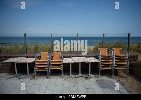 Timmendorfer Strand, Deutschland. Mai 2020. Tische und Stühle sind auf der Terrasse mit Meerblick eines Restaurants an der Strandpromenade in Niendorf zusammengebunden. Quelle: Gregor Fischer/dpa/Alamy Live News Stockfoto