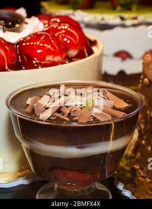 Schokoladenreis Pudding, Dessert in einer Glas transparenten Schüssel in einem Restaurant serviert. Mandeln, Nüsse, Walnuss, Pistazien auf der Oberseite, Schokolade Creme Parfait p Stockfoto