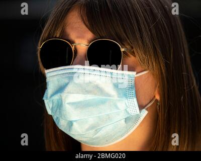 Frau, die während der Sperrung des Coronavirus eine medizinische Schutzmaske trägt Stockfoto