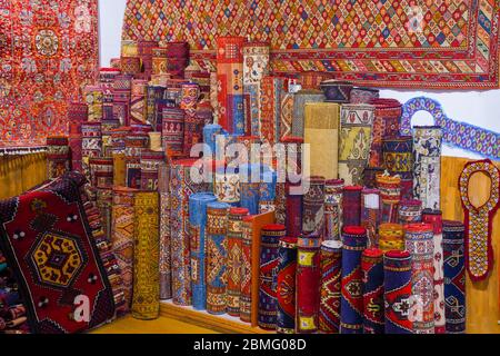 Stapel von schönen handgefertigten Teppichen auf dem offenen Markt Basar. Traditionelles türkisches Design. Stockfoto