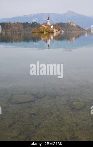 Die berühmte Insel mit Kirche am Bleder See liegt in der Mitte des Sees. Die Wallfahrtskirche Maria in der Mitte des Bleder Sees. Stockfoto