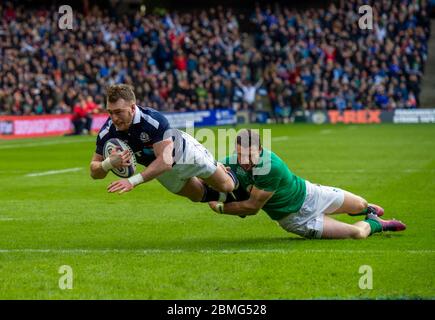 Stuart Hogg aus Schottland versucht sich, als Robbie Henshaw aus Irland ihn während der RBS Six Nations International, Schottland gegen Irland nicht anpacken konnte. Stockfoto