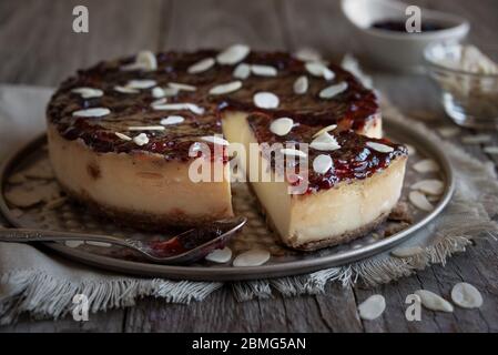 Hausgemachter Käsekuchen mit Fruchtmarmelade und Mandeln Stockfoto