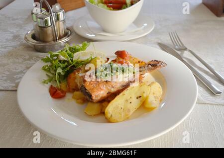 Gebratenes Fischfilet mit Kartoffeln und Salat. Stockfoto