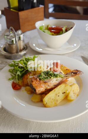 Gebratenes Fischfilet mit Kartoffeln und Salat. Stockfoto