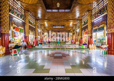 YANGON, MYANMAR - 16. OKTOBER 2015: Verkaufsstände und Händler säumen den Korridor vom südlichen Eingang zur Shwedagon Pagoa. Stockfoto