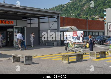 Lugano, Schweiz - 9. Mai 2020: Menschen, die wegen Coronavirus (COVID-19) vor dem Supermarkt Schlange stehen, in Lugano in der Schweiz Stockfoto