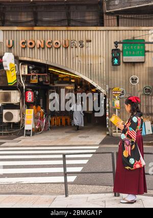 tokio, japan - märz 25 2020: Japanische Frau im Hakama-Kimono, die ein Reiseführer in der Retro-Unterführung Yuraku Concourse der Yurakucho Station liest. J Stockfoto