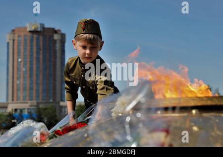 (200509) -- NUR-SULTAN, 9. Mai 2020 (Xinhua) -- EIN kasachische Junge in sowjetischer Armeeuniform legt Blumen auf dem Platz des Verteidigers des Vaterlandes in nur-Sultan, Kasachstan, 9. Mai 2020. Statt Umzüge und Feuerwerk feierte Kasachstan den 75. Jahrestag des Sieges im Großen Vaterländischen Krieg mit kleinen, aber doch herzerwärmenden Ereignissen inmitten der Ausbreitung der COVID-19. (Foto von Kalishan Ospanov/Xinhua) Quelle: Xinhua/Alamy Live News Stockfoto