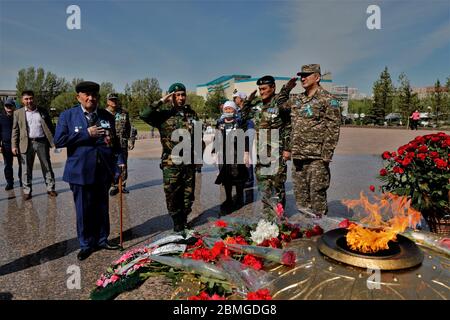 (200509) -- NUR-SULTAN, 9. Mai 2020 (Xinhua) -- Kasachische Veteranen und Militäroffiziere grüßen zur ewigen Flamme auf dem Platz des Verteidigers des Vaterlandes in nur-Sultan, Kasachstan, 9. Mai 2020. Statt Umzüge und Feuerwerk feierte Kasachstan den 75. Jahrestag des Sieges im Großen Vaterländischen Krieg mit kleinen, aber doch herzerwärmenden Ereignissen inmitten der Ausbreitung der COVID-19. (Foto von Kalishan Ospanov/Xinhua) Quelle: Xinhua/Alamy Live News Stockfoto