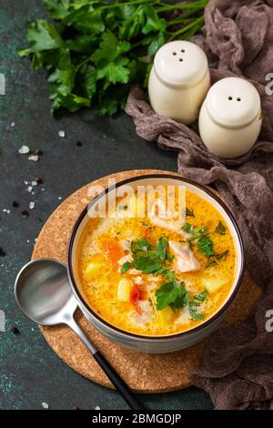 Norwegische Suppe mit Sahne und Lachs auf dunklem Steingrund. Stockfoto