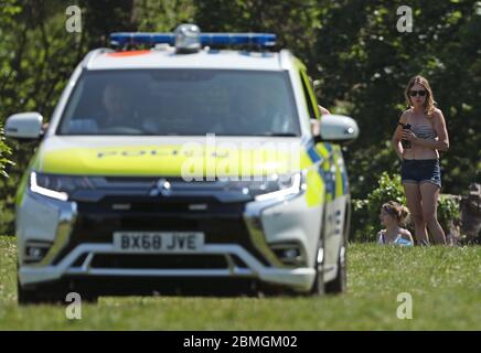 Polizeibeamte in einem Streifenwagen bewegen Sonnenanbeter in Greenwich Park, London, während Großbritannien weiterhin gesperrt wird, um die Ausbreitung des Coronavirus einzudämmen. Stockfoto