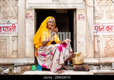 Porträt der alten indischen Frau sitzt auf dem Fenster in pushkar Stockfoto