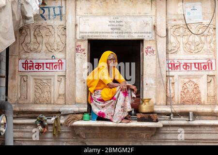 Porträt der alten indischen Frau sitzt auf dem Fenster in pushkar Stockfoto