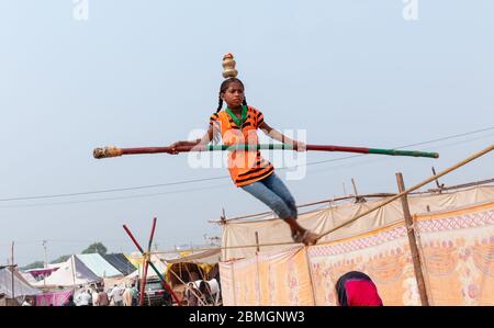 Junges Mädchen Durchführung Akrobatik in engen Seil und balancieren mit Bambus auf Pushkar Fair Stockfoto