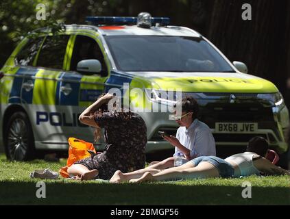 Polizeibeamte in einem Streifenwagen bewegen Sonnenanbeter in Greenwich Park, London, während Großbritannien weiterhin gesperrt wird, um die Ausbreitung des Coronavirus einzudämmen. Stockfoto