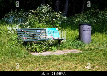 9. Mai 2020, London, Großbritannien - Bank wurde wegen staatlicher Beschränkungen aufgeklebt, um zu verhindern, dass Personen sie während der Sperrung des Coronavirus-Ausbruchs im Tower Hamlets Cemetery Park benutzen, Schild mit der Aufschrift: 'Verwenden Sie diese Bank/Spiel/Fitnessgeräte nicht' Stockfoto