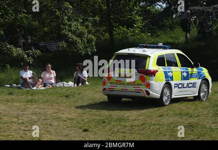 Polizeibeamte in einem Streifenwagen bewegen Sonnenanbeter in Greenwich Park, London, während Großbritannien weiterhin gesperrt wird, um die Ausbreitung des Coronavirus einzudämmen. Stockfoto