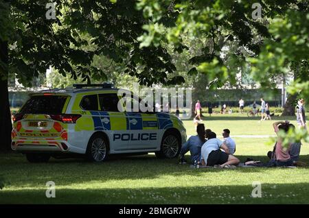 Polizeibeamte in einem Streifenwagen bewegen Sonnenanbeter in Greenwich Park, London, während Großbritannien weiterhin gesperrt wird, um die Ausbreitung des Coronavirus einzudämmen. Stockfoto