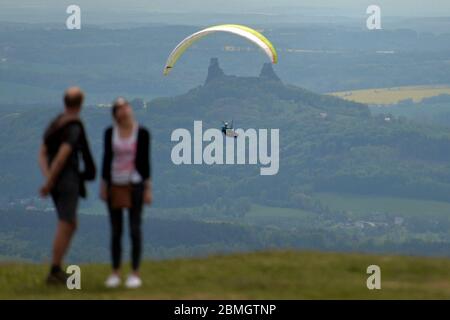 Kozakov, Tschechische Republik. Mai 2020. Ein Paar steht auf der Aussichtsterrasse und beobachtet einen Paragleiter, der über den Kozakov (100 Kilometer nördlich von Prag) in der Tschechischen Republik fliegt. Paragliding ist ein Freizeit- und Wettkampfsport. Der Pilot sitzt in einem Gurtzeug unter einem Stoffflügel, dessen Form durch den Druck der Luft gebildet wird, die in die Lüftungsschlitze vor dem Flügel eindringt. Kredit: Slavek Ruta/ZUMA Wire/Alamy Live News Stockfoto