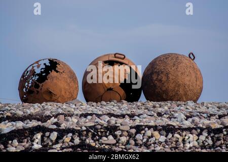 Drei große rostige Bojen am Ufer Stockfoto