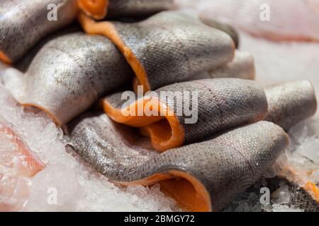 Gekühltes Filet von rotem Fisch. Fischstücke liegen auf Eis. Ladentisch für Tiefkühlschränke. Der Fisch liegt auf Eis. Lachs. Nahaufnahme Foto. Stockfoto