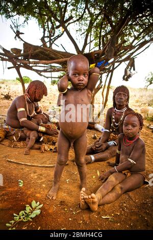 Familie Hamer auf ihrem Bauernhof. Der kleine Zubo, aufrecht, seine Schwester Selaki, rechts. Im Hintergrund ihre Mutter Dobo mit ihrem jüngsten Sohn Aike und ihrem aun Stockfoto