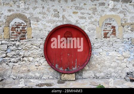 Rotes Fass an Steinwand am Weinhaus Stockfoto