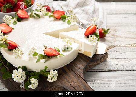 Hausgemachter Käsekuchen mit Erdbeeren auf Holzhintergrund dekoriert Stockfoto