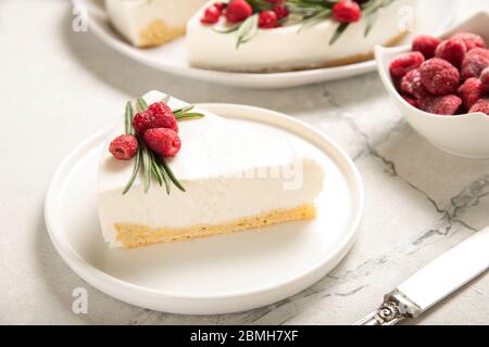 Eine Scheibe Käsekuchen mit Himbeeren auf einem Teller. Nahaufnahme. Stockfoto