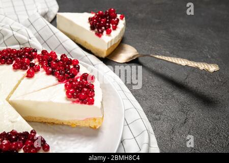 Teller mit köstlichem Käsekuchen und frischen Beeren auf dem Tisch Stockfoto