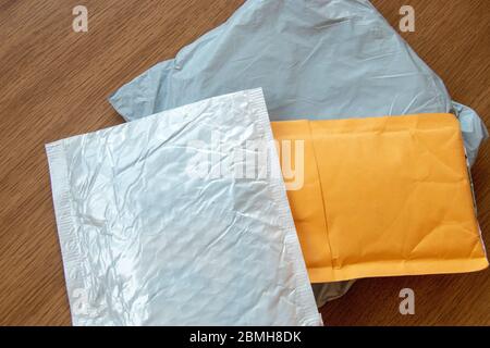 Drei Postpakete kleine Packung weiß, grau und gelb lagen auf Holzhintergrund Stockfoto