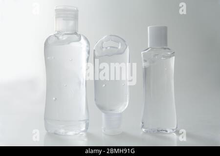 Antibakterielles Gel in verschiedenen Behältern mit grauem Hintergrund Stockfoto