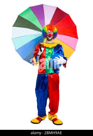 In voller Länge Porträt eines lustigen Clowns mit einem bunten Regenschirm Stockfoto