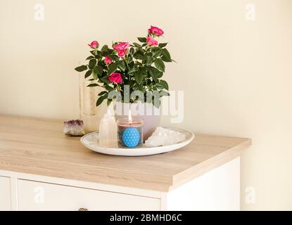 Brennende Glaskerze mit selbstgemachtem Schild, das das Symbol Blume des Lebens im Inneren mit Halbedelstein-Geoden zeigt. Spirituelle Symbole zu Hause. Stockfoto