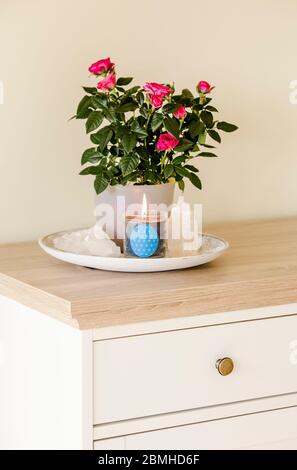 Brennende Glaskerze mit selbstgemachtem Schild, das das Symbol Blume des Lebens im Inneren mit Halbedelstein-Geoden zeigt. Spirituelle Symbole zu Hause. Stockfoto