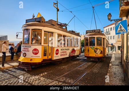 Die Trolleys fahren entlang der Largo Santa Luzia, während sie an der katholischen Kirche Igreja de Santa Luzia im Stadtteil Alfama in Lissabon, Portugal, vorbeifahren. Stockfoto