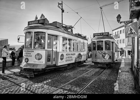 Die Trolleys fahren entlang der Largo Santa Luzia, während sie an der katholischen Kirche Igreja de Santa Luzia im Stadtteil Alfama in Lissabon, Portugal, vorbeifahren. Stockfoto