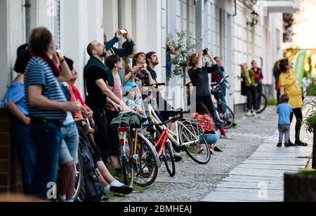 Berlin, Berlin, Deutschland. Mai 2020. Mehrere Leute versammeln sich auf dem Bürgersteig, während der Musiker Junk-E-CAT ein spontanes Konzert auf dem Dach eines Hauses gibt. Der Berliner Musiker Junk-E-CAT verbindet akustische und elektronische Elemente und kombiniert nahtlos eine Auswahl an Reed-Instrumenten mit Fingerdrumming und Live-Looping. Seit dem 4. Mai sind Open-Air-Meetings mit bis zu 50 Teilnehmern grundsätzlich genehmigungsfrei, sofern die Distanz- und Hygienevorschriften eingehalten werden. Quelle: Jan Scheunert/ZUMA Wire/Alamy Live News Stockfoto