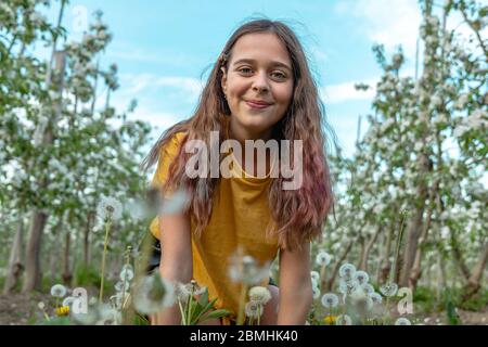 Nahaufnahme eines lässigen Studenten Mädchen mit Brünette Mädchen, das den Frühlingstag in den blühenden Garten genießen Stockfoto