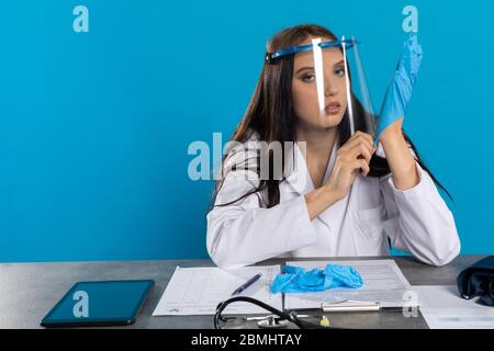 Vor dem Besuch des Patienten bereitet sich der Arzt darauf vor, sich nicht versehentlich mit einer Infektionskrankheit zu infizieren. Stockfoto