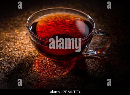 Tasse köstlichen Rooibos Tee auf dunklem Hintergrund Stockfoto