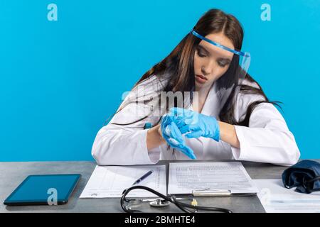 Vor dem Besuch des Patienten bereitet sich der Arzt darauf vor, sich nicht versehentlich mit einer Infektionskrankheit zu infizieren. Stockfoto