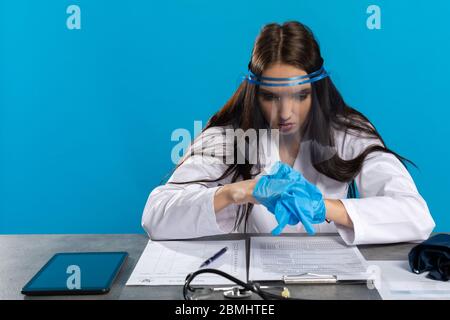 Vor dem Besuch des Patienten bereitet sich der Arzt darauf vor, sich nicht versehentlich mit einer Infektionskrankheit zu infizieren. Stockfoto