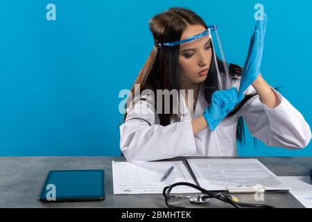 Vor dem Besuch des Patienten bereitet sich der Arzt darauf vor, sich nicht versehentlich mit einer Infektionskrankheit zu infizieren. Stockfoto