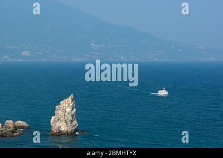 Panoramablick auf die Schwarzmeerküste. Weißes Schiff auf dem türkisfarbenen Wasser des Meeres. Rock Sail, Jalta Stockfoto