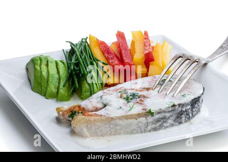 Lachssteak mit cremiger Sauce und gemischtem Gemüse auf weiß isoliert Stockfoto